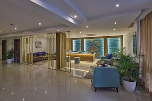 A spacious lobby with a reception desk, seating area, and decorative elements.