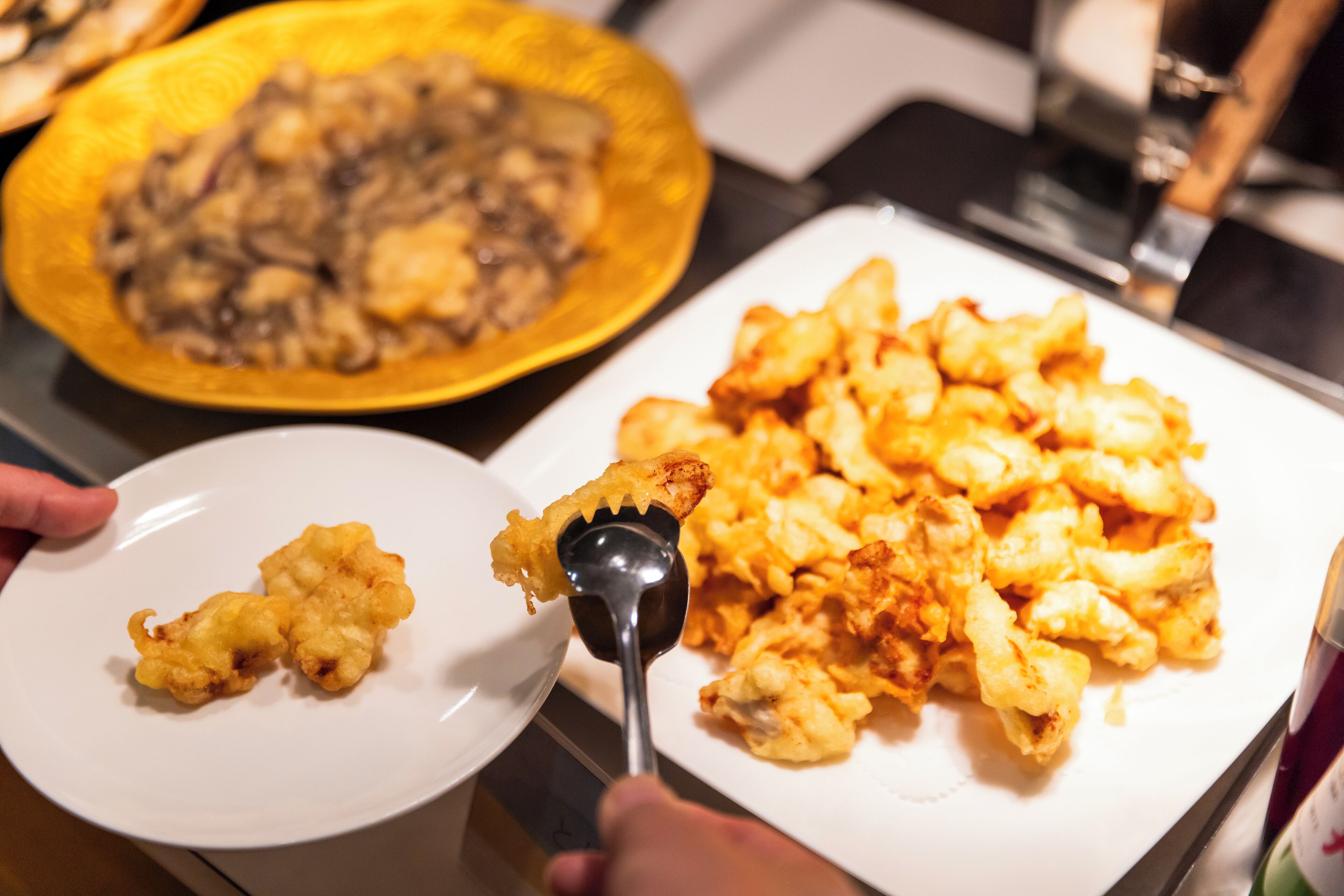 A plate of fried food with a serving spoon.