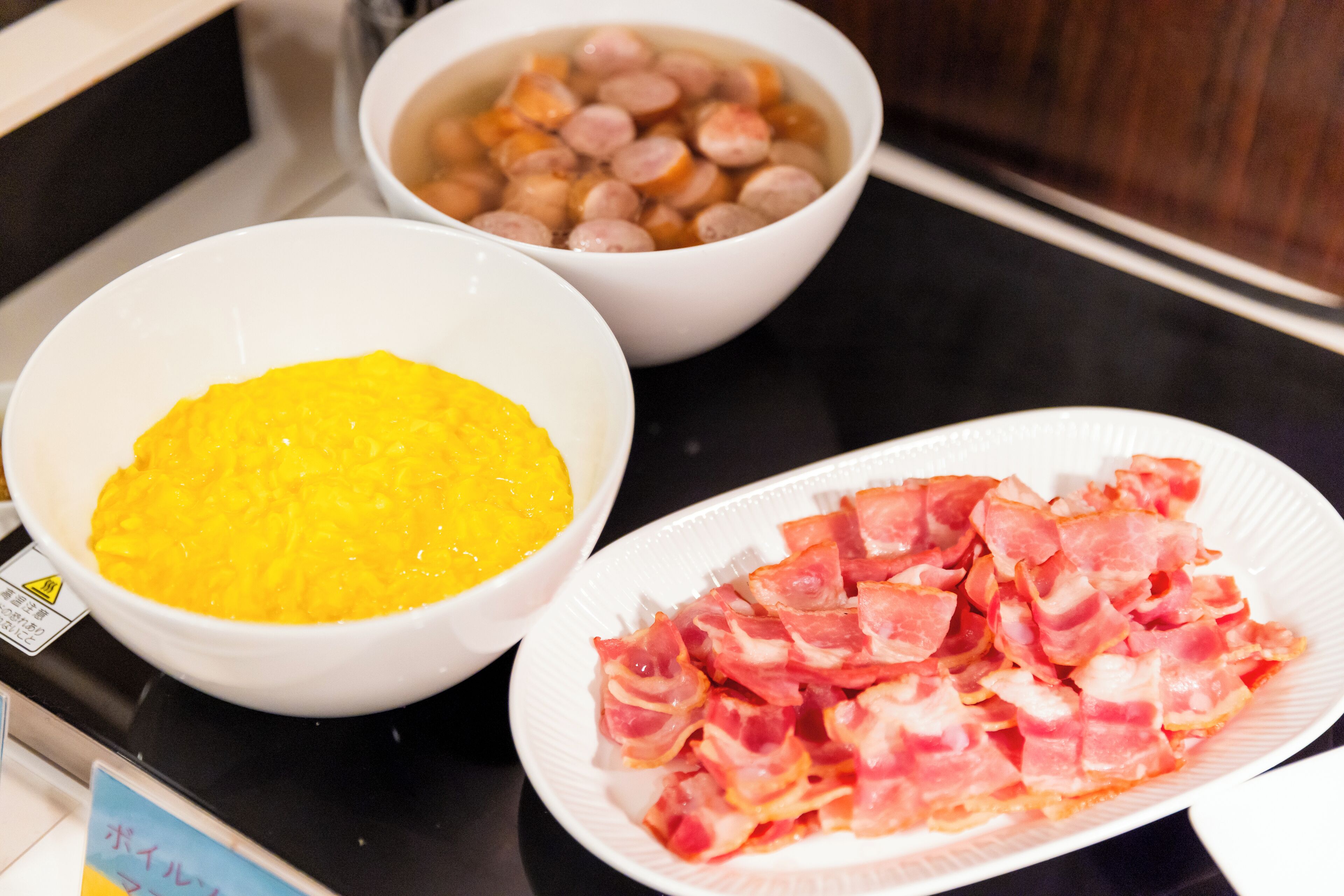 A kitchen counter with three bowls containing food items.