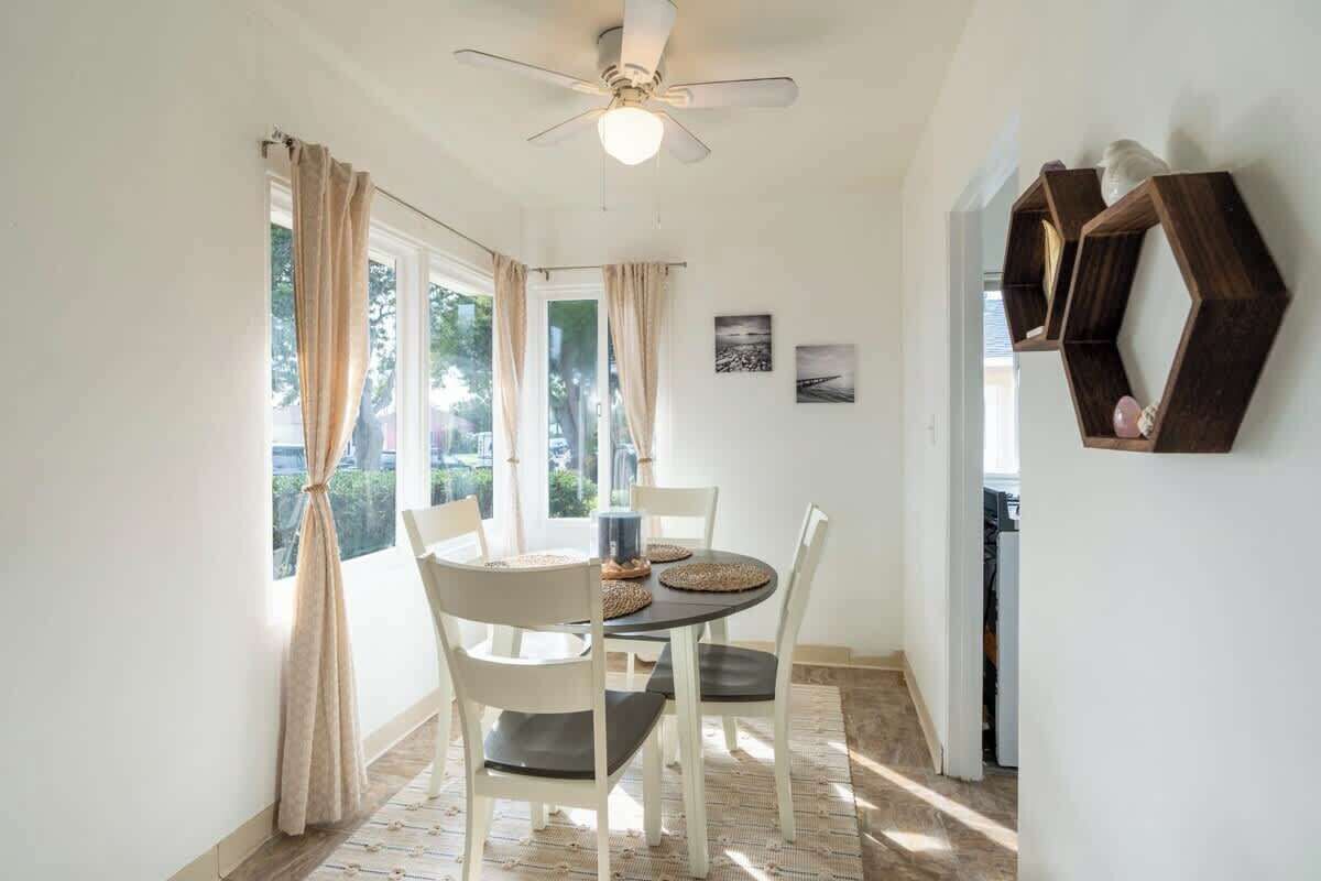 A dining area with a table, chairs, and a ceiling fan.