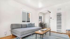 A modern living room with a grey sofa, a wooden coffee table, and a striped rug.