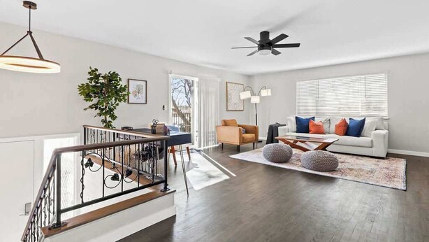 A spacious living area with a staircase, a dining area, and a sofa set. - Hot Tub Family Home with Mountain Views - Close to Red Rocks and Clear Creek! (Golden)