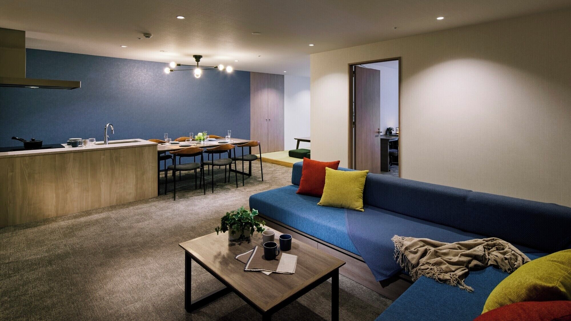 A modern apartment with a kitchen, dining area, and living room.