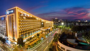 A modern hotel with a prominent sign, multiple floors, and a well-lit facade. - the Star Hotel (Zhaoqing)