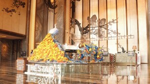 A reception area with a large decorative waterfall, a reception desk, and a wall with vertical wooden panels and hanging decorations. - the Star Hotel (Zhaoqing)