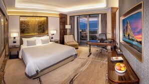 A hotel room with a large bed, a desk with a chair, a laptop, and a painting of a bridge. - the Star Hotel (Zhaoqing)