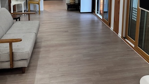 Un salon moderne avec un canapé à motif pied-de-poule, une table ronde et une grande fenêtre offrant une belle vue.
