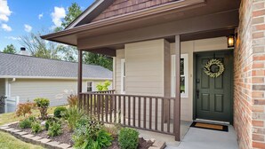 A house with a covered porch, a front door with a wreath, and a landscaped garden. - 1.5  Miles to Mizzou! ~ Spacious & Updated Home~ (Columbia)