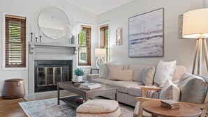 A modern living room with a fireplace, a sofa, a coffee table, and a lamp. - 1.5  Miles to Mizzou! ~ Spacious & Updated Home~ (Columbia)