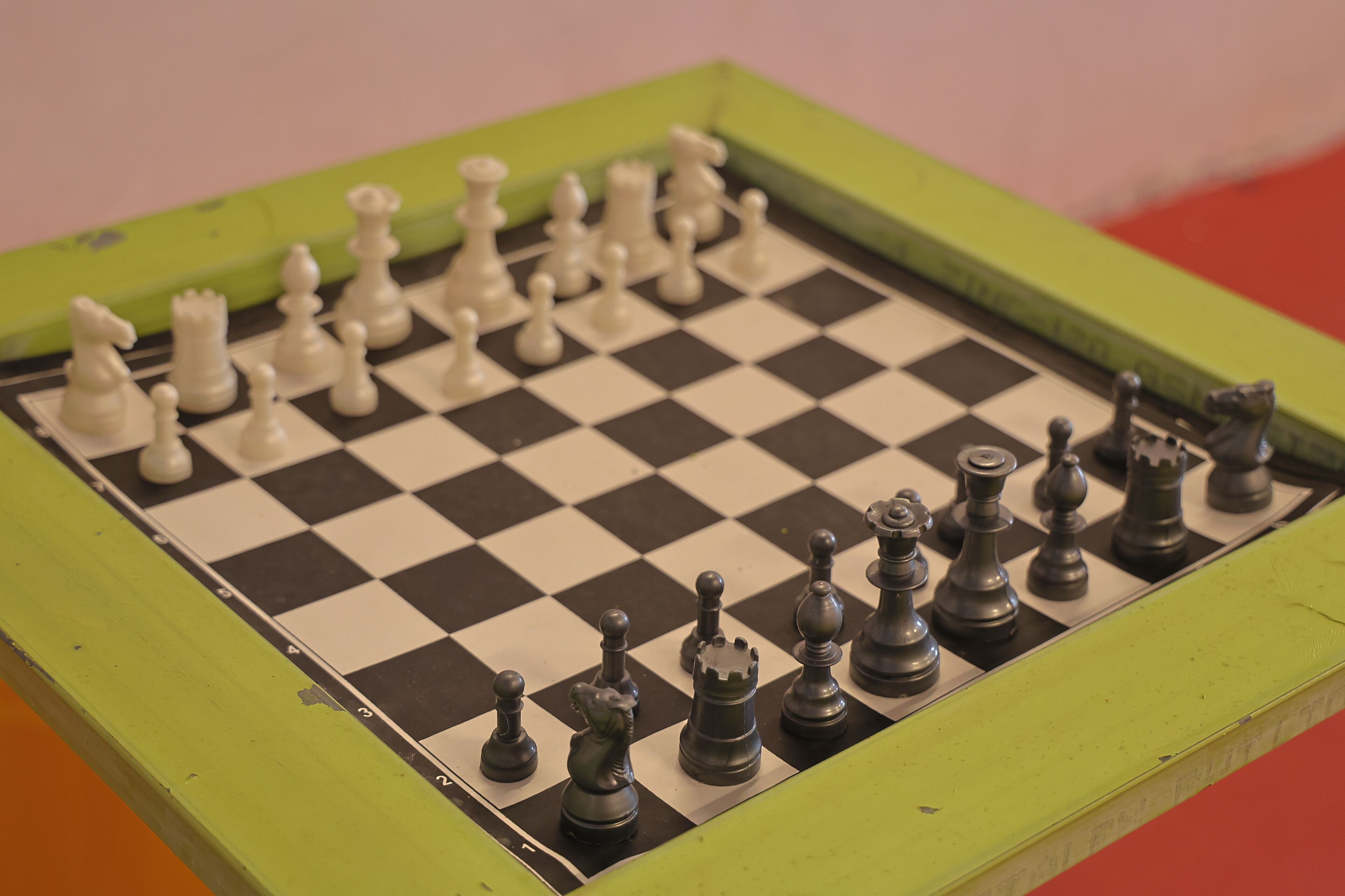 Un tablero de ajedrez con piezas en medio de la partida, rodeado de un marco verde.