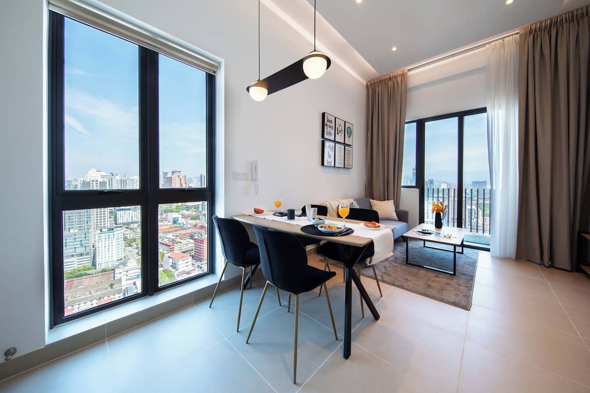A modern dining area with a city view, a dining table, chairs, and a coffee table.