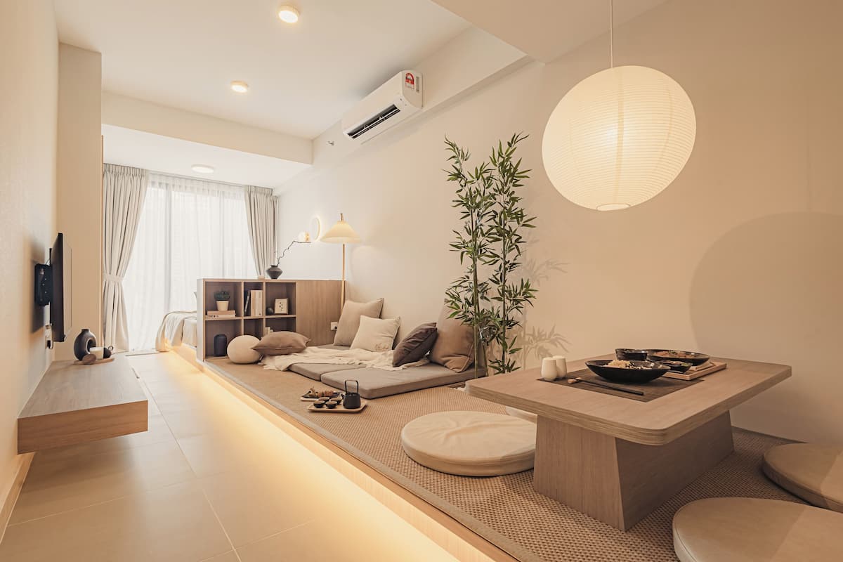 A modern living room with a sofa, a dining area with a table, and a large plant.