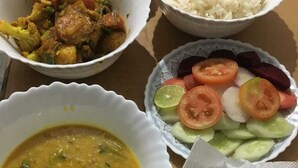 A meal consisting of rice, a vegetable curry, a lentil soup, a salad, and flatbreads. - Hotel Bodhgaya Inn By GRB (Gaya)