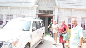 A group of people walking towards a building with a large arched entrance. - Hotel Bodhgaya Inn By GRB (Gaya)