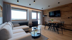 En moderne stue med sofa, sofabord og spiseplads.