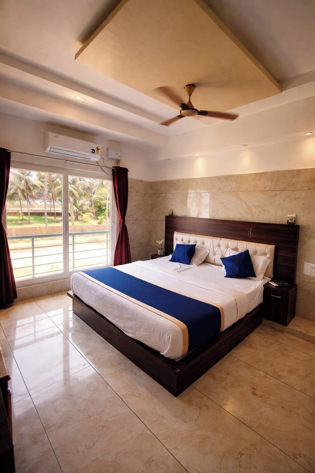 A large bed with a wooden headboard, a ceiling fan, and an air conditioning unit.