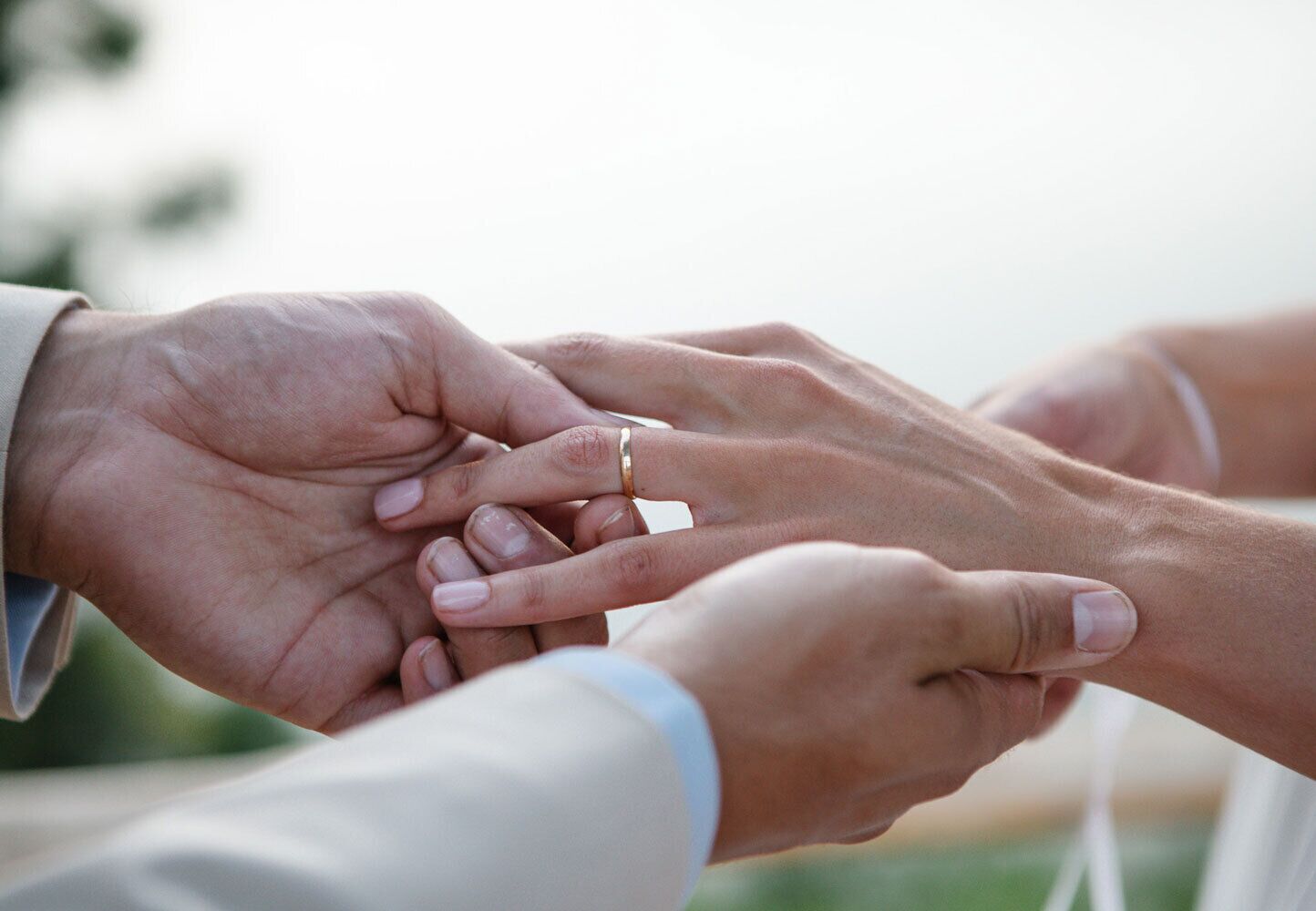A close-up of hands exchanging a ring.