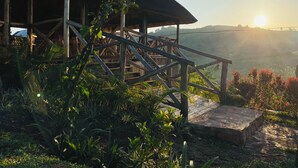 Eine Holzhütte mit einem Reetdach mit Blick auf eine üppige Landschaft.