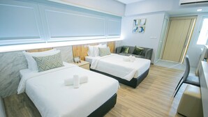 A hotel room with two beds, a desk, and a wardrobe. - Wellness World Chiva 89 (Bangkok)