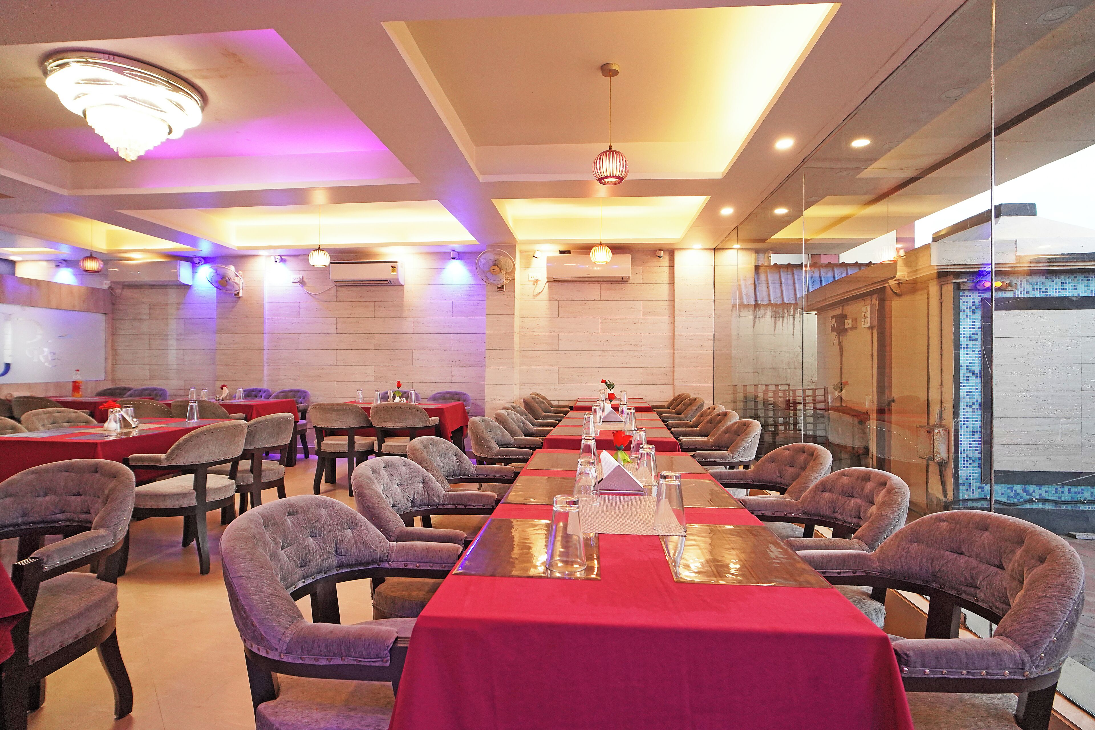 A conference room with a long table, multiple chairs, and a chandelier.