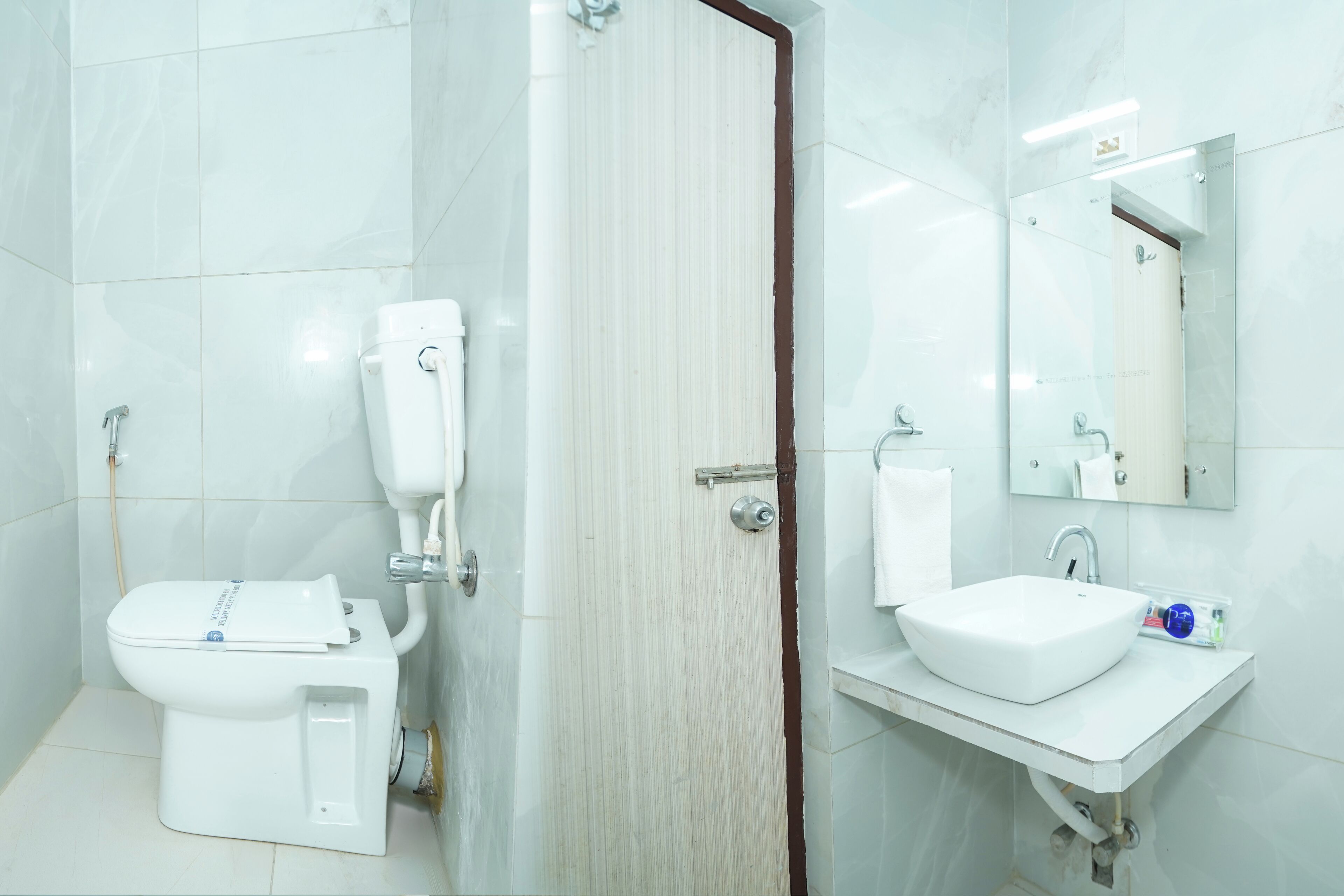 Un baño moderno con inodoro, lavabo, espejo y bidé.