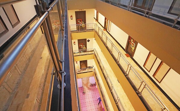 Ένας χώρος με πολλαπλά επίπεδα, μεταλλικά κάγκελα, πλακάκι στο δάπεδο και μια σκάλα.