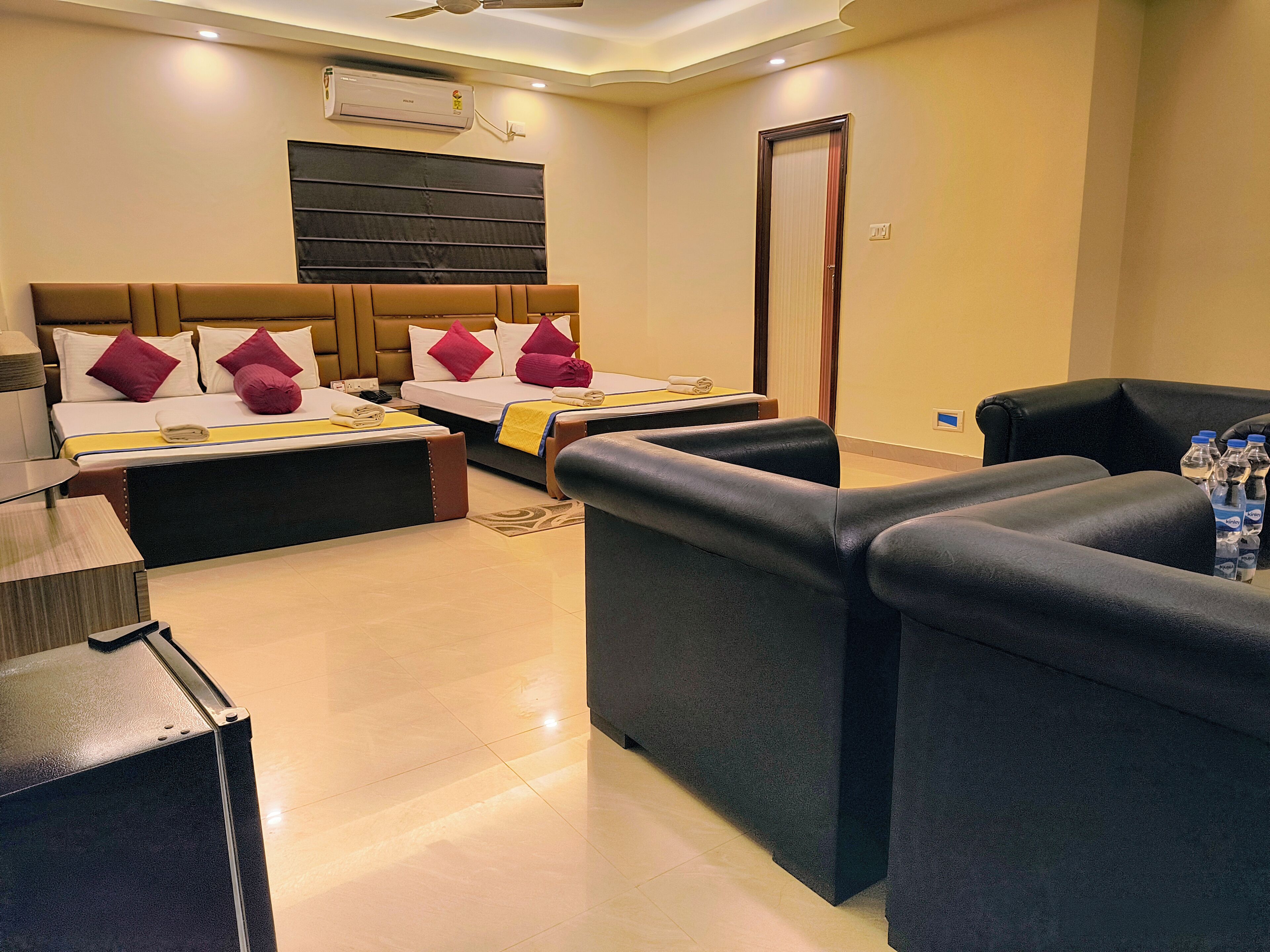 A hotel room with a bed, two bedside tables, a sofa, a desk, and a chair.