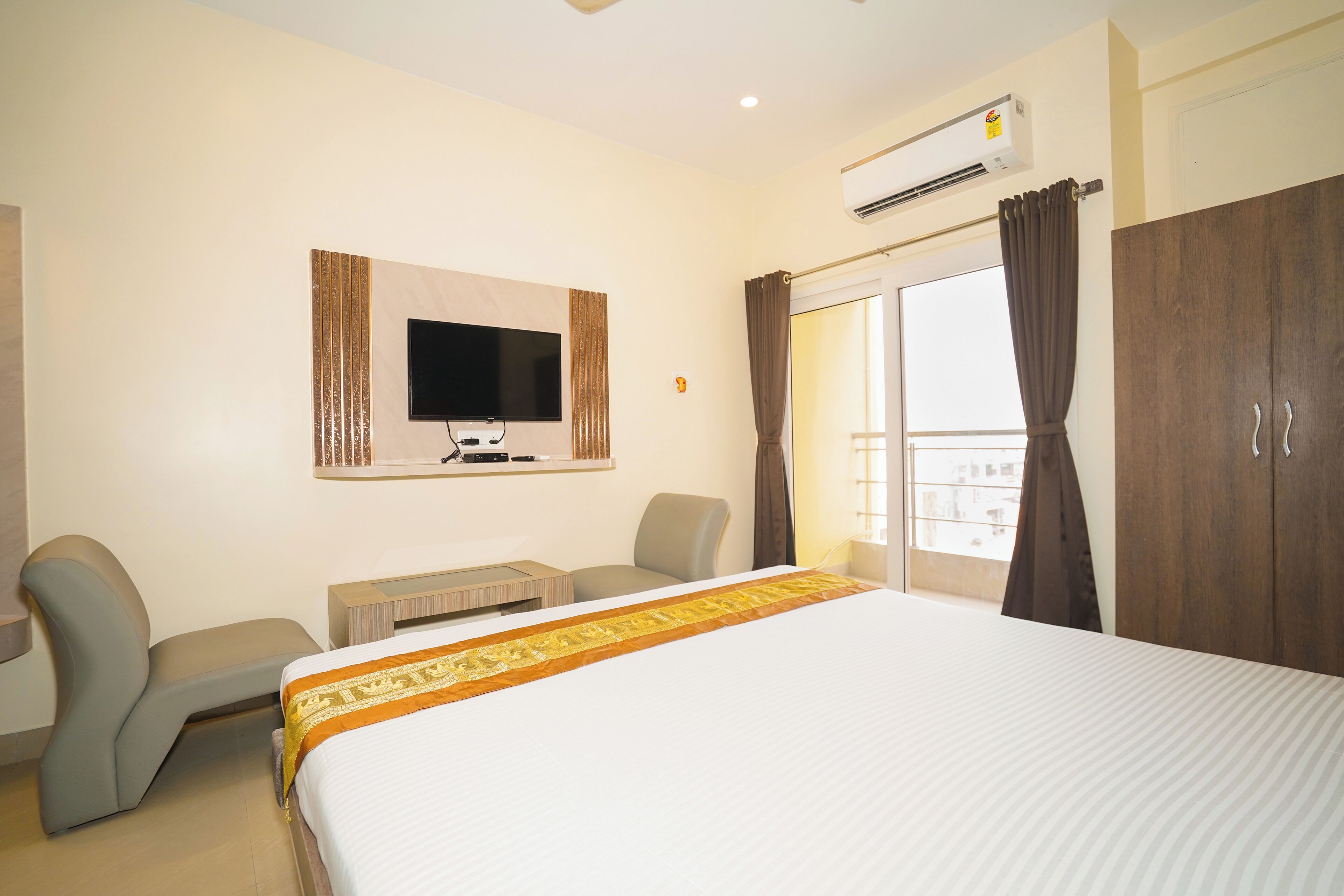 Une chambre d’hôtel équipée d’un lit, d’un bureau, d’une chaise, d’une télévision et d’une armoire.