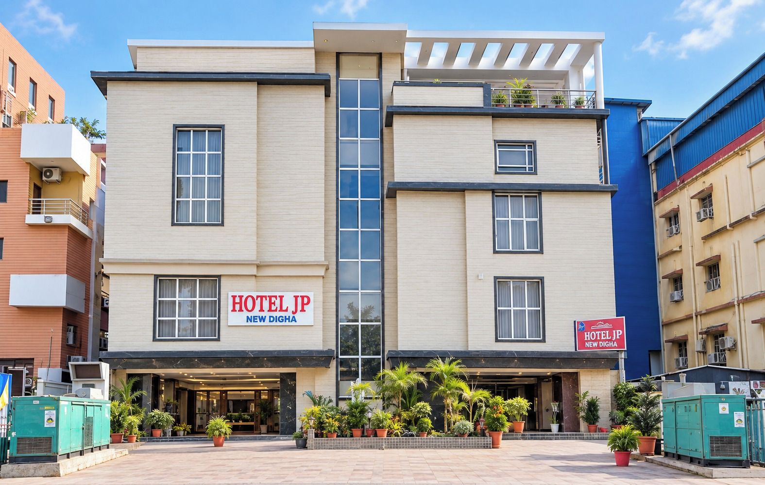 Un bâtiment d’hôtel avec une enseigne indiquant « HÔTEL JP NEW DIGHA ».
