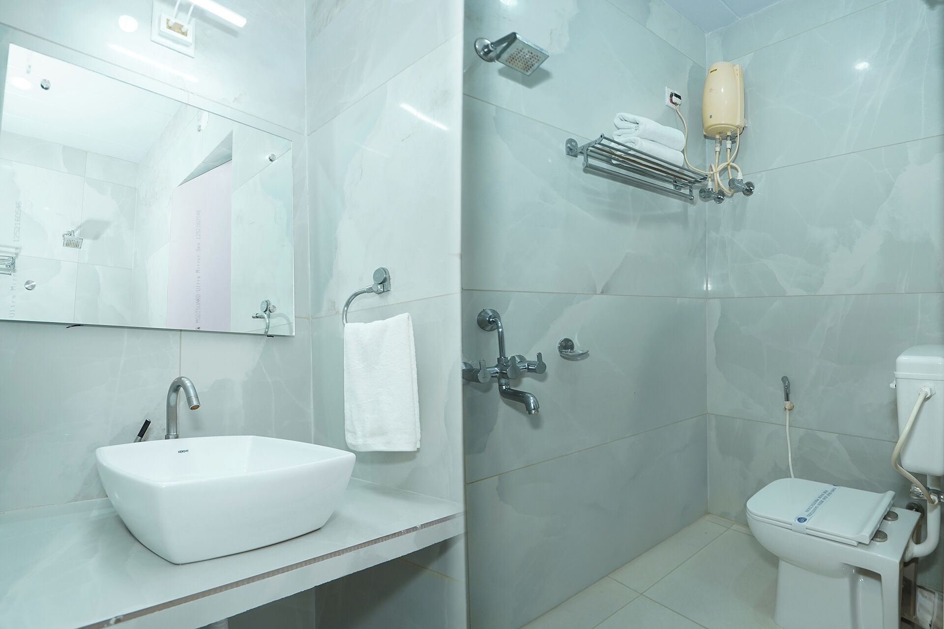 A modern bathroom with a white sink, mirror, and toilet.