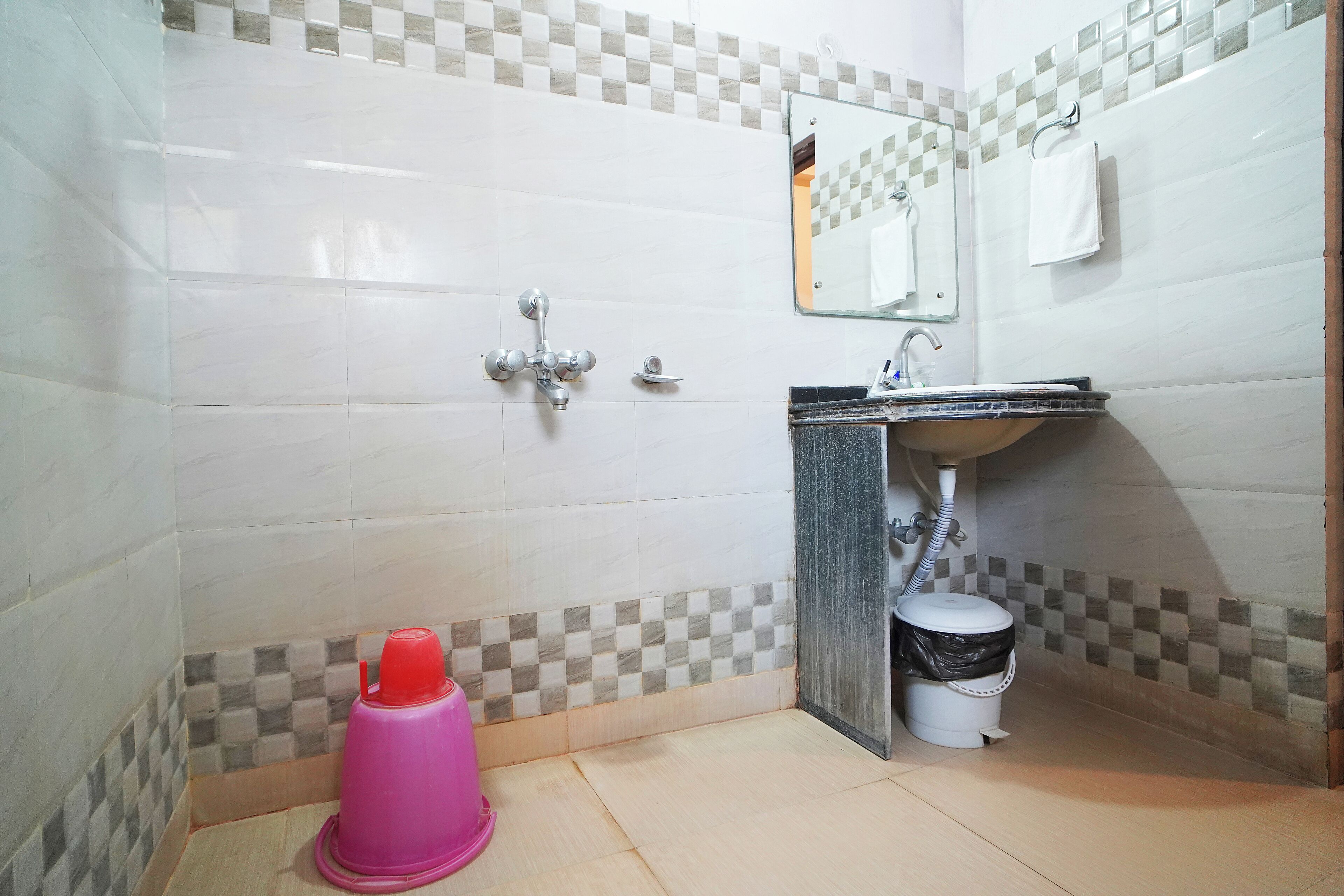 Un bagno con lavandino, specchio e pareti piastrellate.
