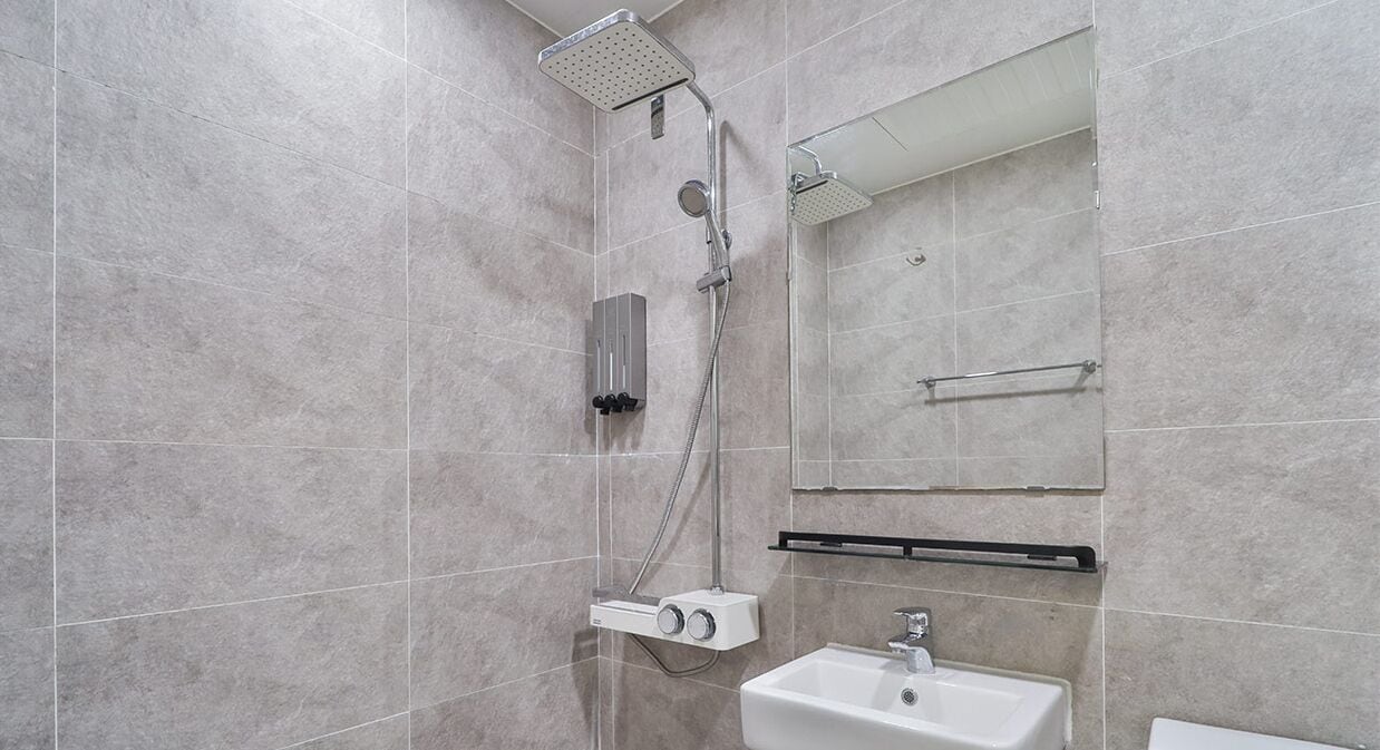 A modern bathroom with a shower, sink, and mirror.