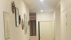A hallway with wooden flooring, white walls, and a door at the end. - Apartment Paris 11 - 2 bedrooms - 2 shower rooms - 2 toilets (Paris)