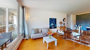 Un salon moderne avec un canapé, une table basse et un coin repas.