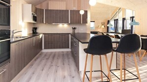 Une cuisine moderne avec des meubles en bois, un îlot central et des tabourets de bar.