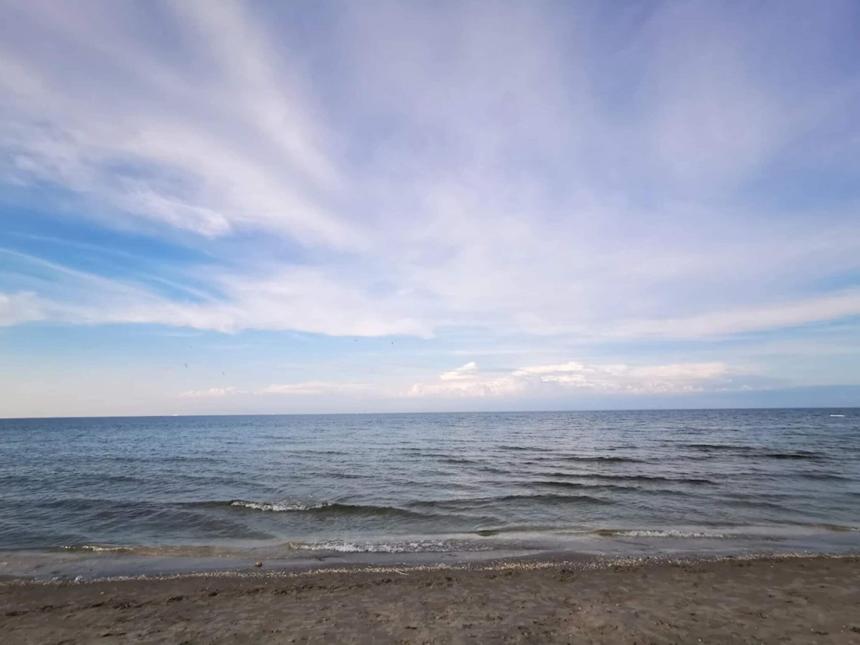 A beach with calm water and a clear sky.