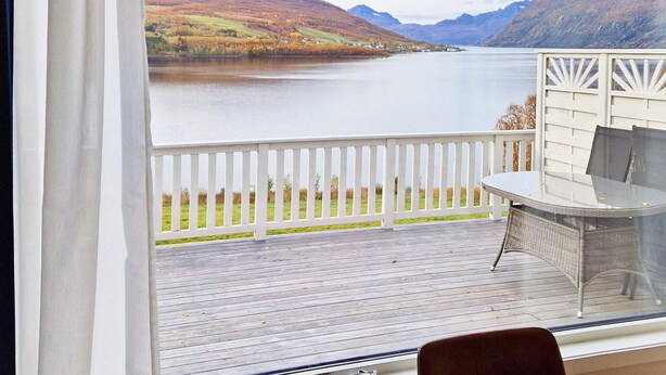 Un balcon avec vue sur un lac et des montagnes.