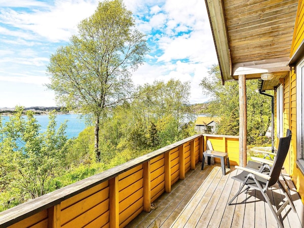A wooden deck with a view of a lake and trees.