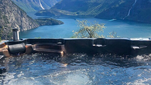 Un bateau sur un lac, avec des montagnes en arrière-plan.