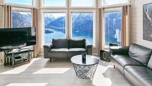Un salon spacieux doté d’une grande fenêtre donnant sur un paysage montagneux.