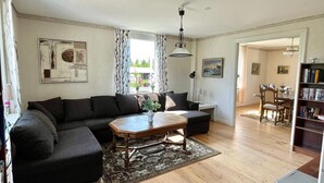 A living room with a sectional sofa, a coffee table, and a bookshelf. - 5 Person Holiday Home in Morlunda (Mörlunda)
