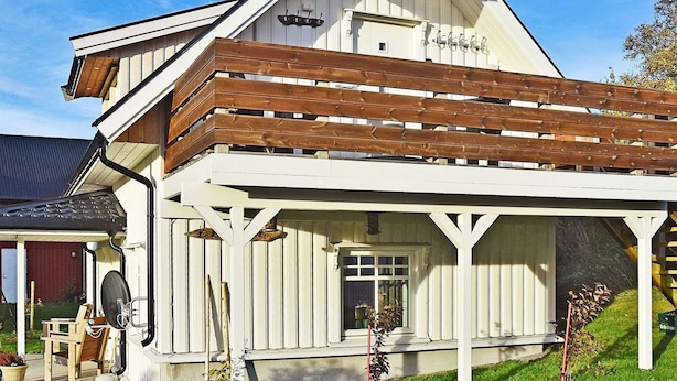A white building with a sloped roof and wooden beams. - 4 Person Holiday Home in Oksvoll (Orland)