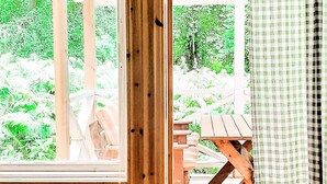 A wooden deck with a table and chairs, surrounded by lush greenery. - 4 Person Holiday Home in Braas (Braås)