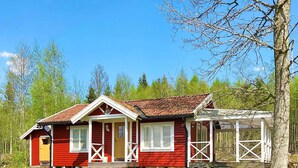 A red wooden house with a porch and a covered area. - 4 Person Holiday Home in Braas (Braås)
