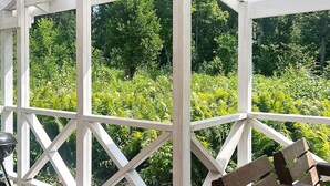 A covered outdoor area with a wooden deck, white railing, and benches. - 4 Person Holiday Home in Braas (Braås)