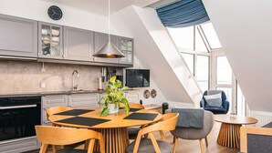 Cocina moderna con comedor, que incluye una mesa redonda de madera, sillas y una planta en maceta.