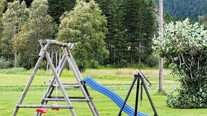 A wooden swing set with a blue slide in a grassy park area. - 8 Person Holiday Home in Terrak (Bindal)