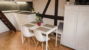 A kitchen with a dining table, chairs, and a potted plant. - Stylish House in the Countryside 5 km From the sea (Darlowo)