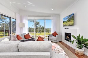 A modern living room with a grey sofa, a flat-screen TV, and a fireplace. - Two for Joy Estate. Sleeping 12, 2 Cottages (North Rothbury)