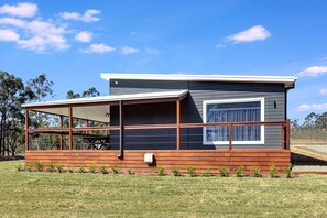 A modern two-story cabin with a covered patio area and a large window. - Two for Joy Estate. Sleeping 12, 2 Cottages (North Rothbury)